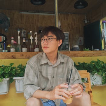 Casual scene of a young man enjoying an iced coffee at a cafe in Vietnam.