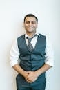 Portrait of a cheerful man in business attire posing confidently indoors.